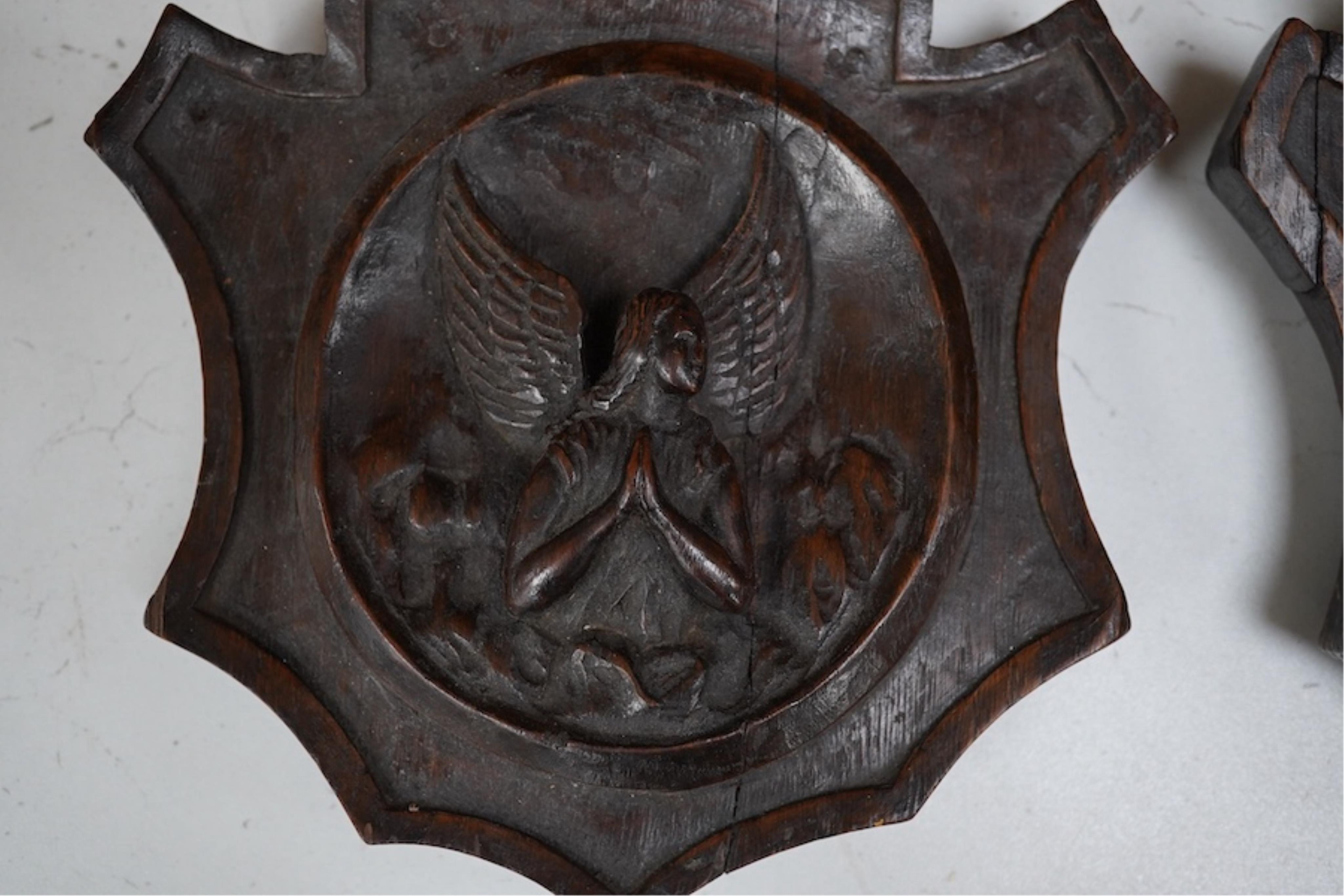 A pair of 19th century carved oak shields, one of an angel the other an eagle. 19.5cm high. Condition - good